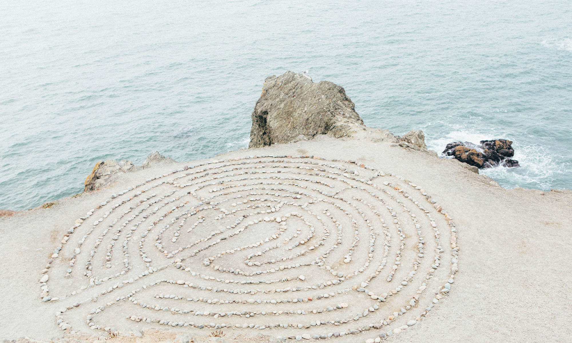 Steinlabyrinth vor Meer